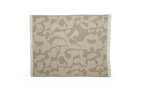 Beige plaid med tone‑i‑tone abstrakt mønster og frynser i kanterne på hvid baggrund.