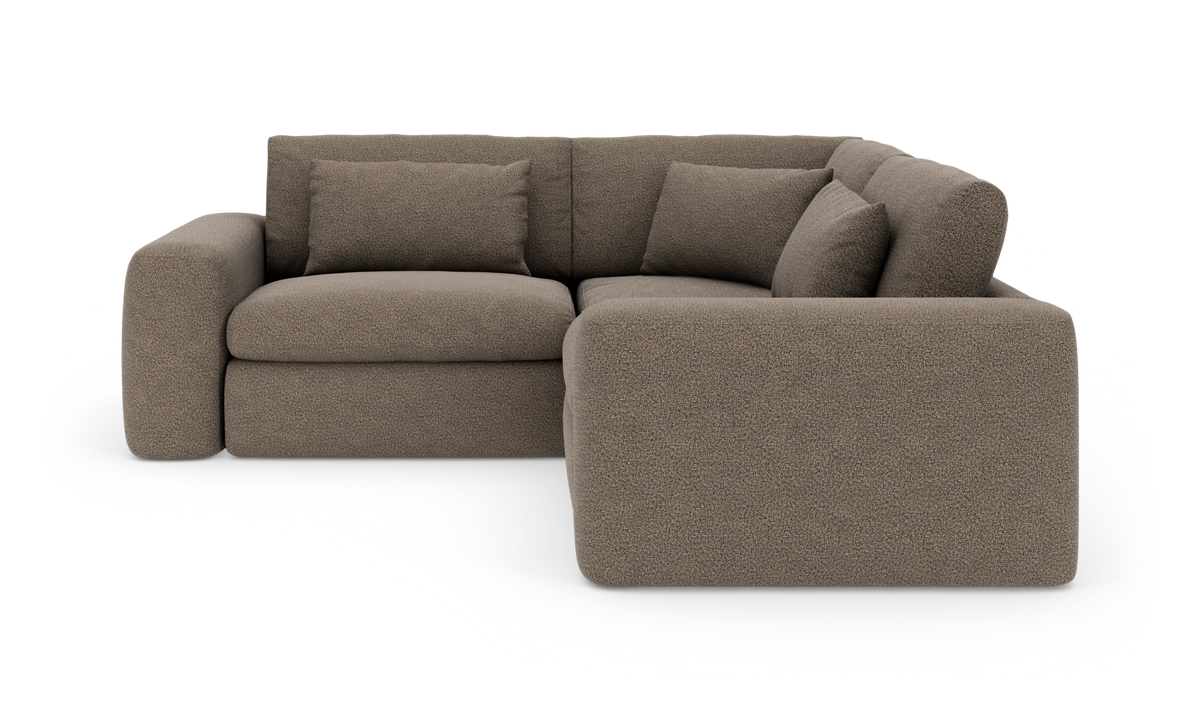 Brun hjørnesofa med bløde, afrundede former og tre puder, højrevendt chaiselong.