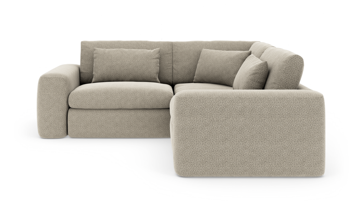 L‑formet beige modulsofa med brede afrundede armlæn og løse rygpuder.