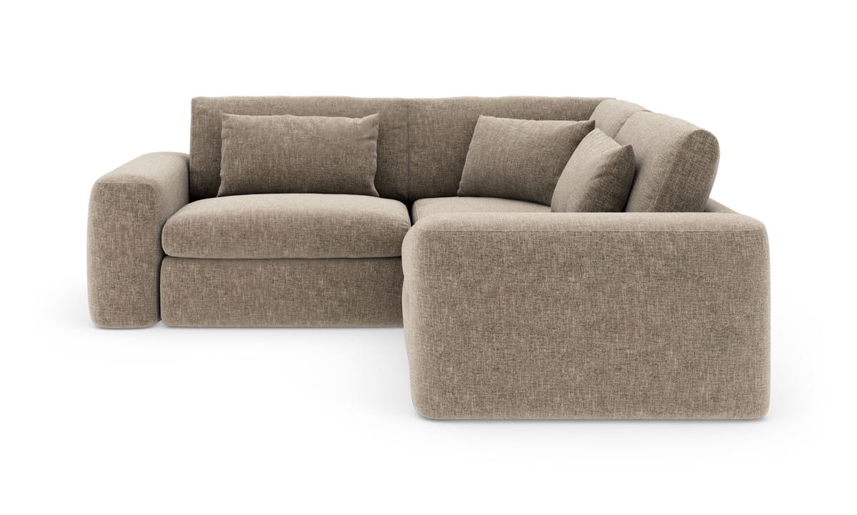 Beige hjørnesofa med bløde afrundede former og løse ryghynder, frilagt på hvid baggrund.