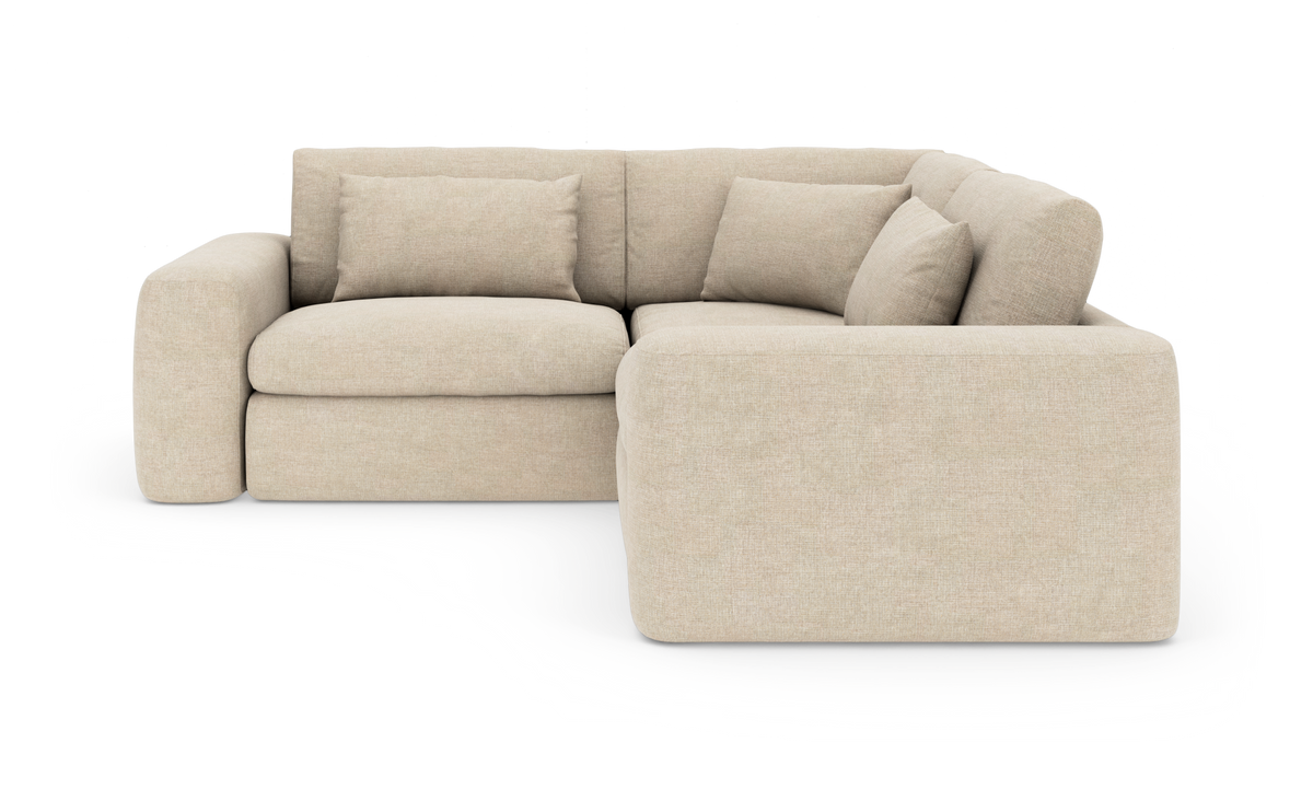 Beigefarvet modul-hjørnesofa med chaiselong og løse puder, isoleret på hvid baggrund.