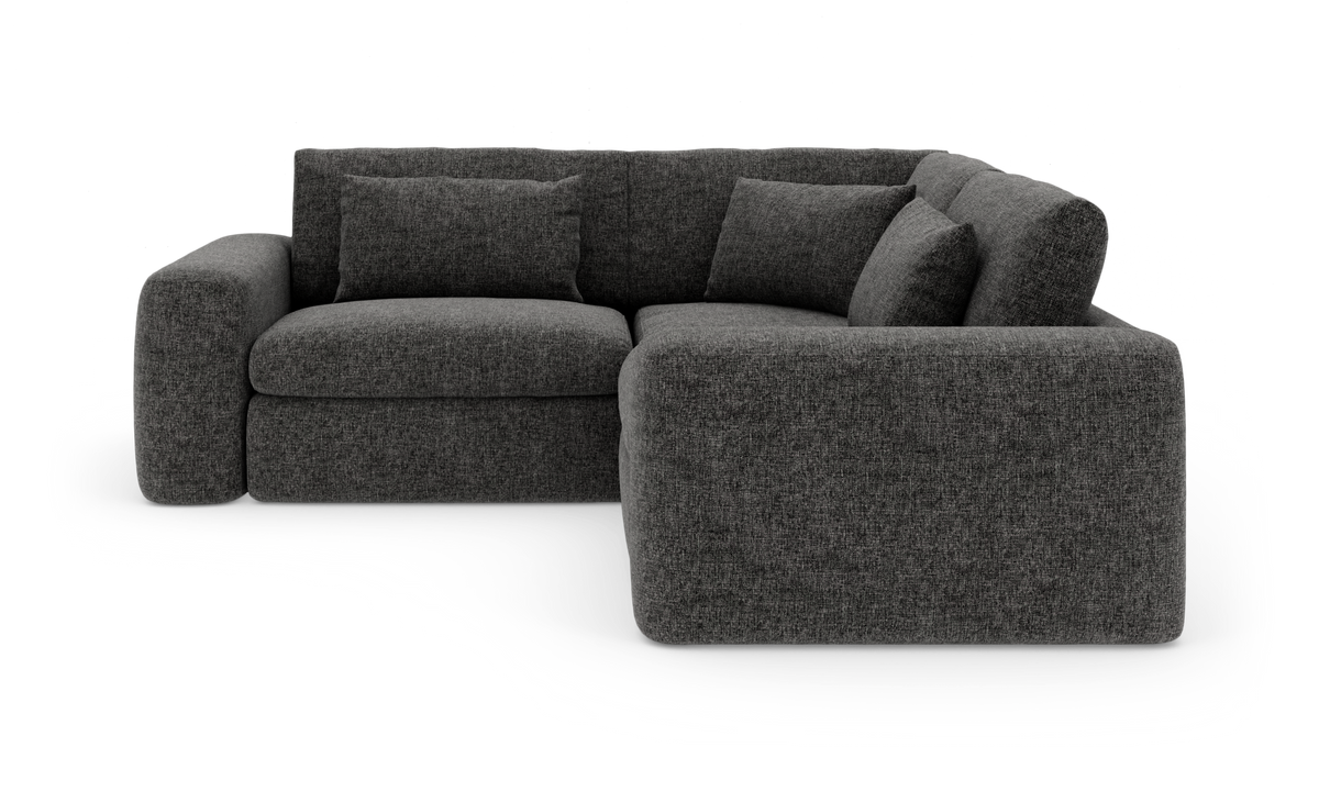 Mørkegrå L‑sofa i tekstil med afrundede armlæn og tre rygpuder, højrevendt chaiselong.