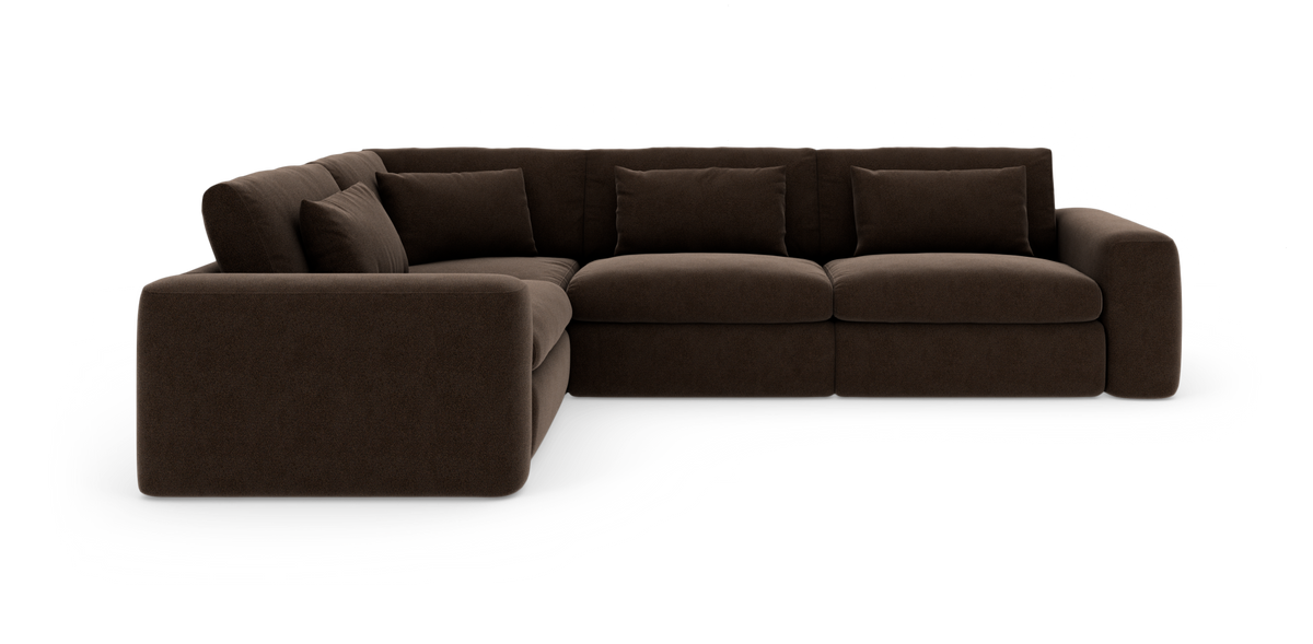 Mørkebrun modul-hjørnesofa med bløde, brede armlæn og løse ryghynder, frilagt på hvid baggrund.