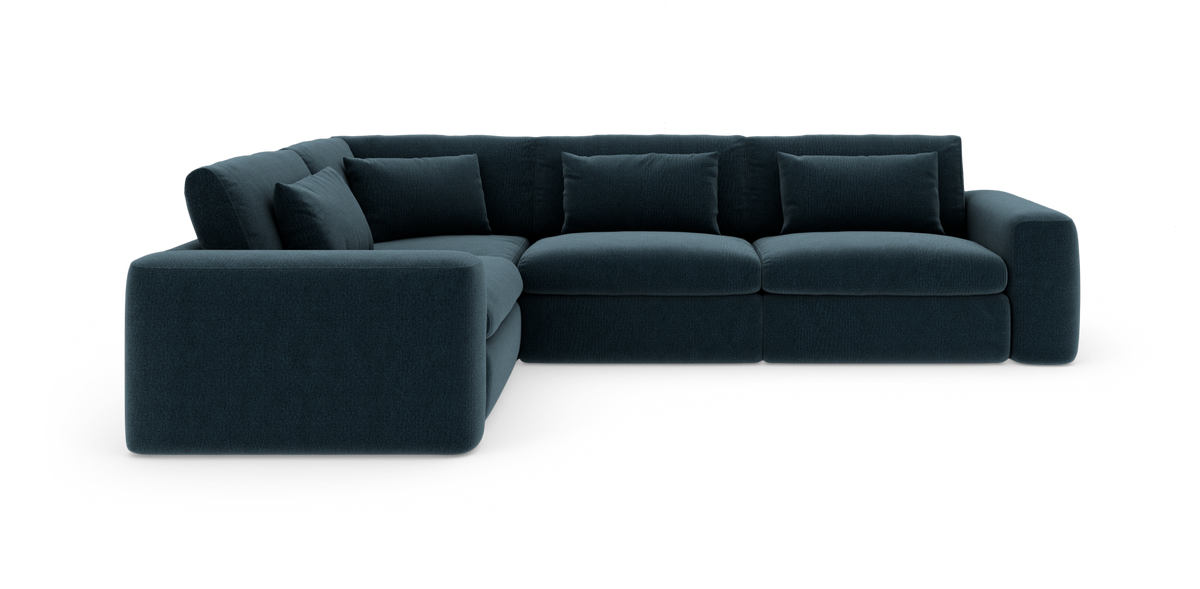 Mørkeblå modul-hjørnesofa med bløde, afrundede armlæn og løse ryghynder, frilagt på hvid baggrund.