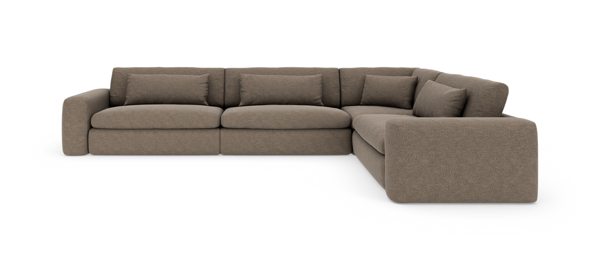 Brun L‑formet modulsofa med brede armlæn og løse ryghynder, fotograferet i studie mod hvid baggrund.
