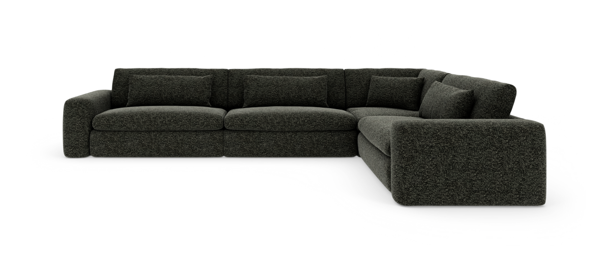Mørkegrå L-formet modulsofa med bløde, dybe puder, vist skråt forfra på hvid baggrund.