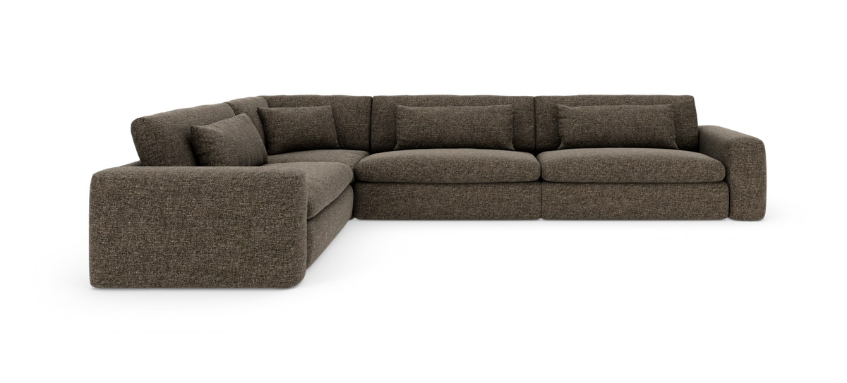Brun L‑formet modulsofa med afrundet hjørne, fyldige sædehynder og løse rygpuder, fotograferet skråt forfra på hvid baggrund.