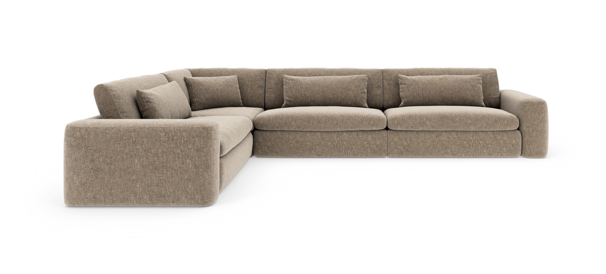 Beige modulær L‑sofa i stof med afrundede armlæn og løse ryghynder.