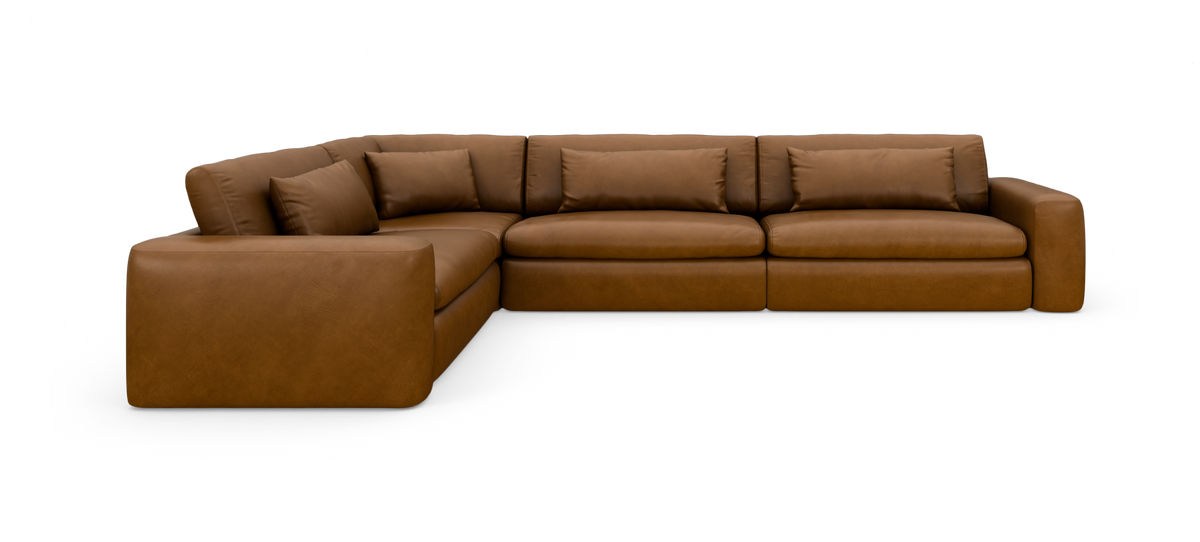 Brun læder hjørnesofa med brede armlæn og løse ryghynder, frilagt på hvid baggrund.