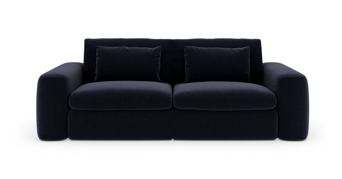 Mørkeblå sofa med to siddepuder, brede armlæn og to ryghynder, fritlagt på hvid baggrund.