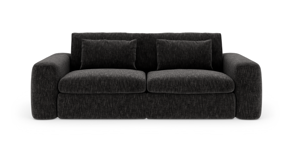 Mørkegrå sofa med brede armlæn, to rygpuder og to sædehynder, frilagt på hvid baggrund.
