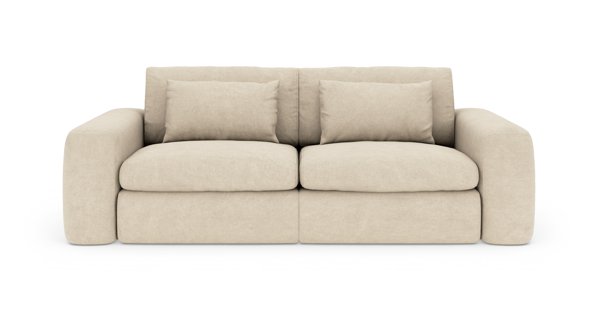 Beige 2‑personers sofa med brede armlæn og fire løse ryghynder, frilagt på hvid baggrund.