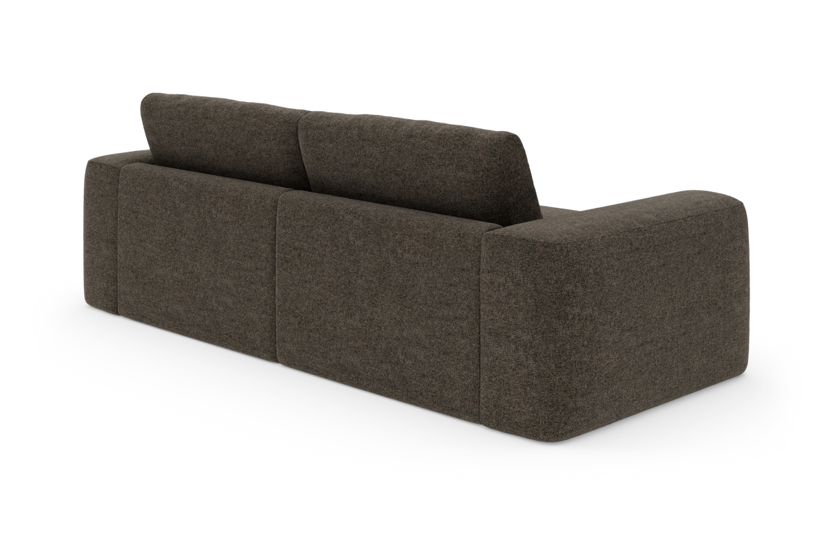 Mørkebrun modulsofa i tekstil set skråt bagfra på hvid baggrund.