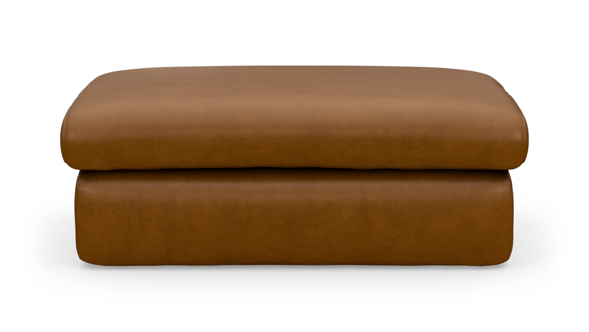 Brun læderpuf/ottoman set forfra på hvid baggrund.