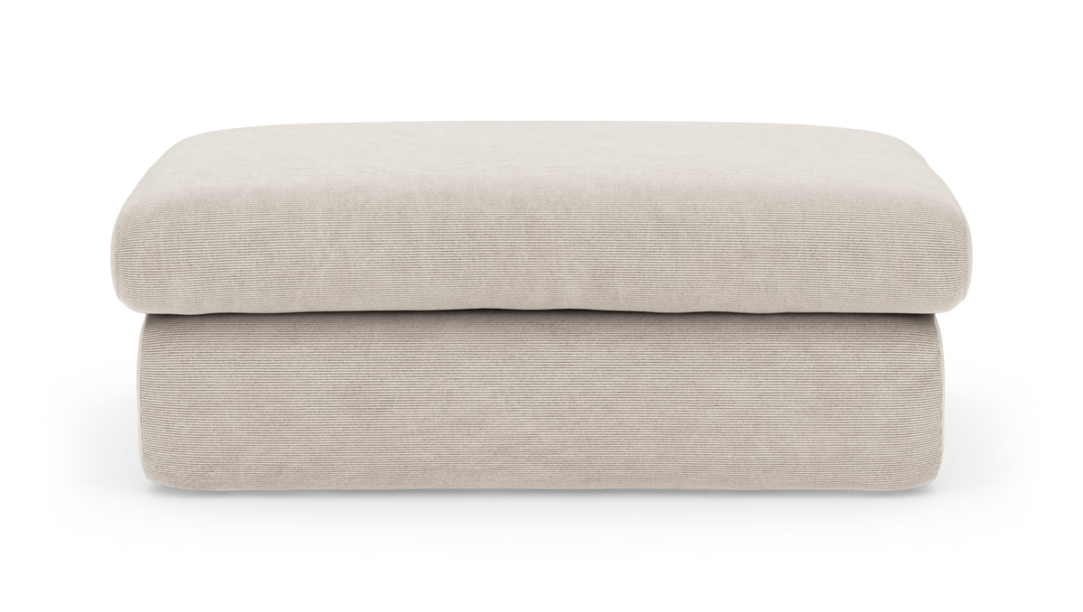 Beige, lav puf/ottoman med blød riflet polstring, frontvisning.