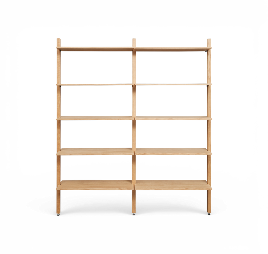 Minimalistisk, fritstående reol i lyst træ med to fag og fem hylder pr. sektion, set forfra.