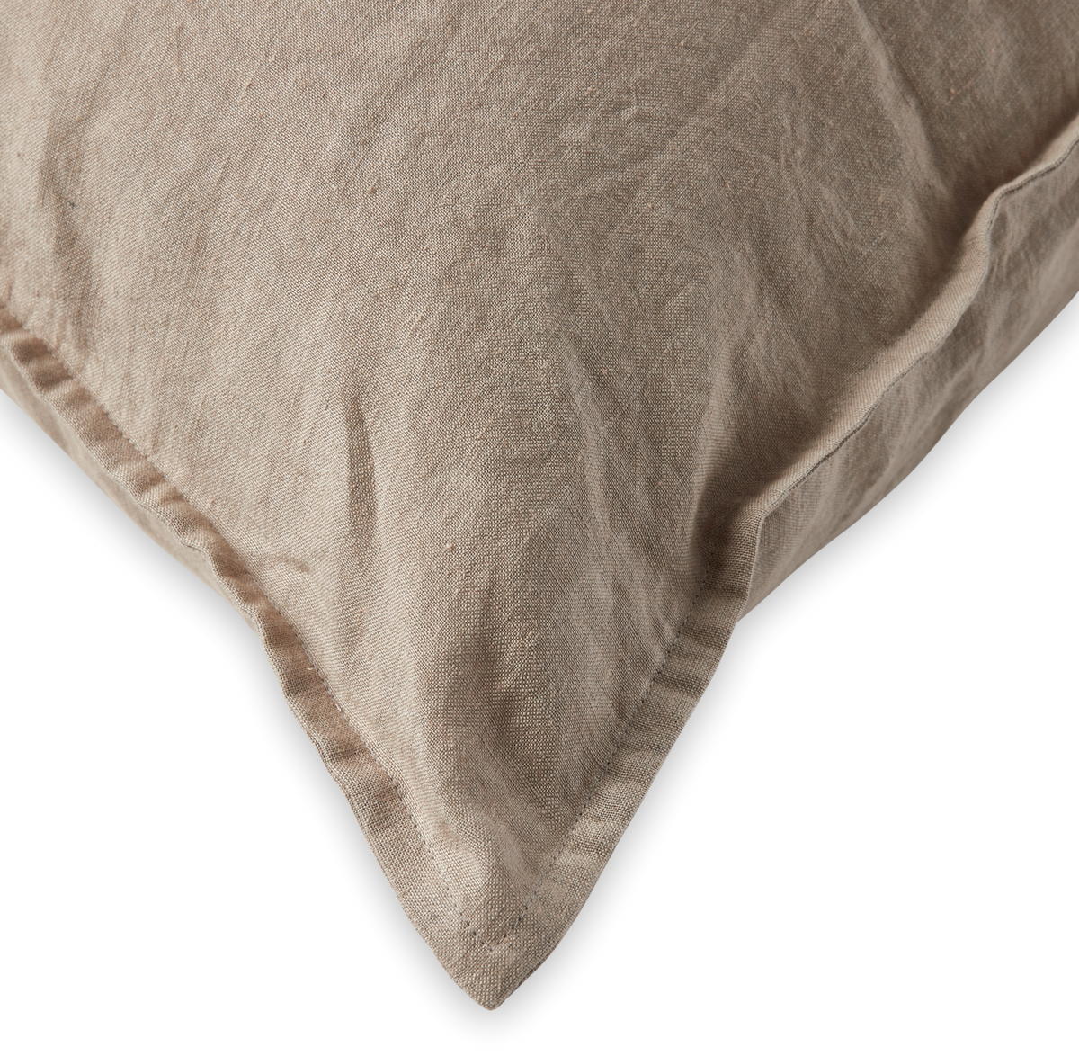 Nærbillede af en beige linnedpude med kant mod sort baggrund.