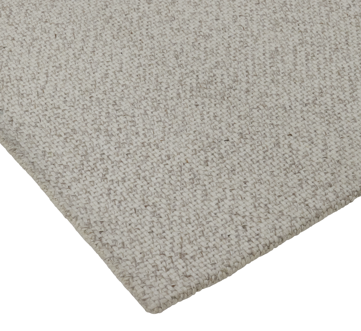 Nærbillede af lys beige vævet tæppe med grov struktur set fra et hjørne.