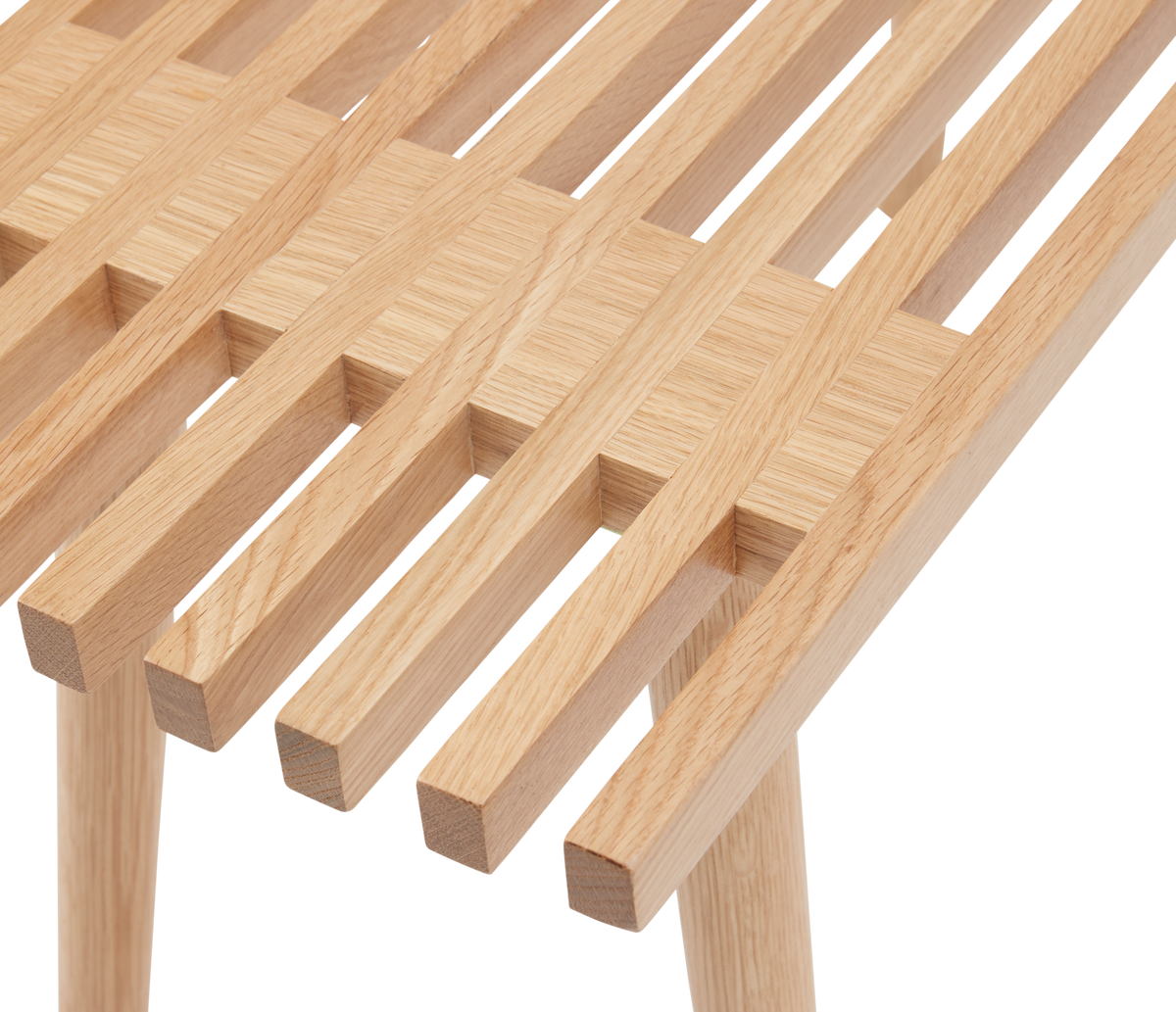 Nærbillede af en lys egetræsbænk med lameller i et minimalistisk design.