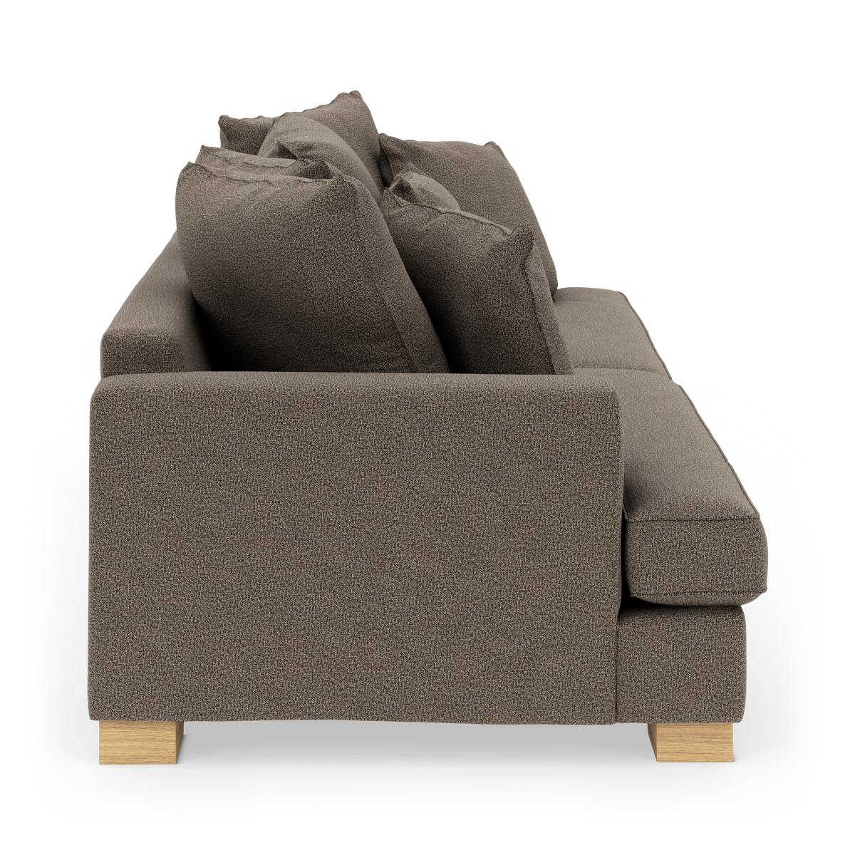 Brun stofsofa set fra siden med løse rygpuder og træben.