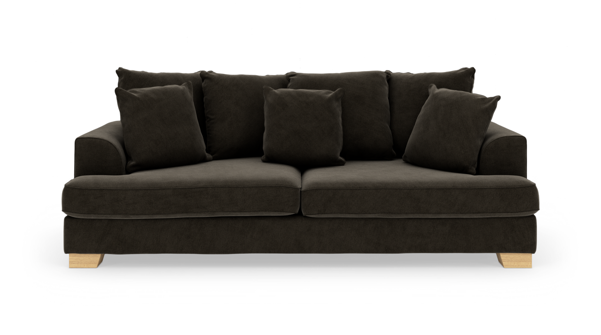 Mørkebrun sofa med løse puder og lyse træben, fritlagt på hvid baggrund.