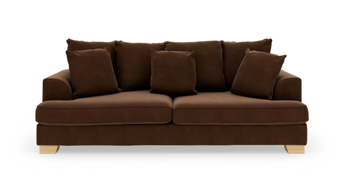 Brun stofsofa med fem løse ryghynder, to sædehynder og lyse træben, frilagt på hvid baggrund.