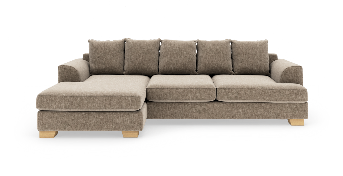 Beige hjørnesofa med chaiselong til venstre, stofbetrukket og med lyse træben, fritlagt på hvid baggrund.