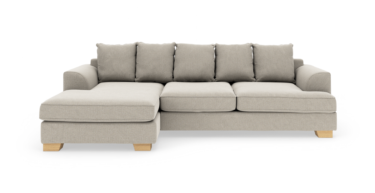 Beige hjørnesofa med chaiselong til venstre og træben, frilagt på hvid baggrund.