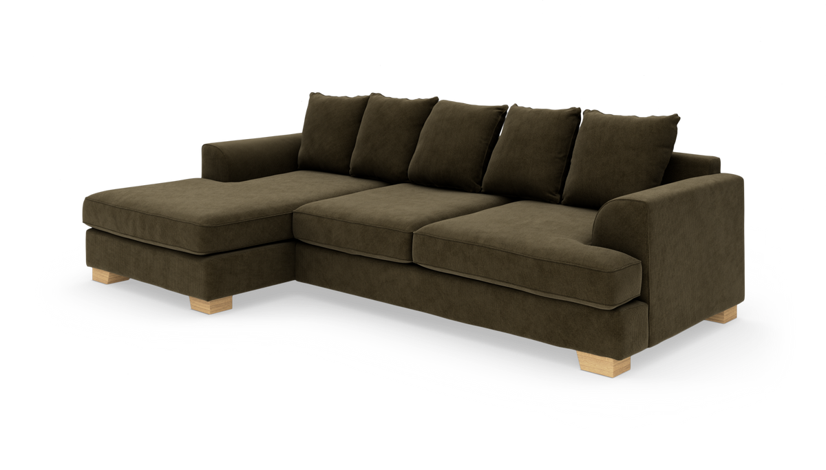 Modulsofa i olivgrøn fløjl med venstrevendt chaiselong og lyse træben, fritstående mod hvid baggrund.