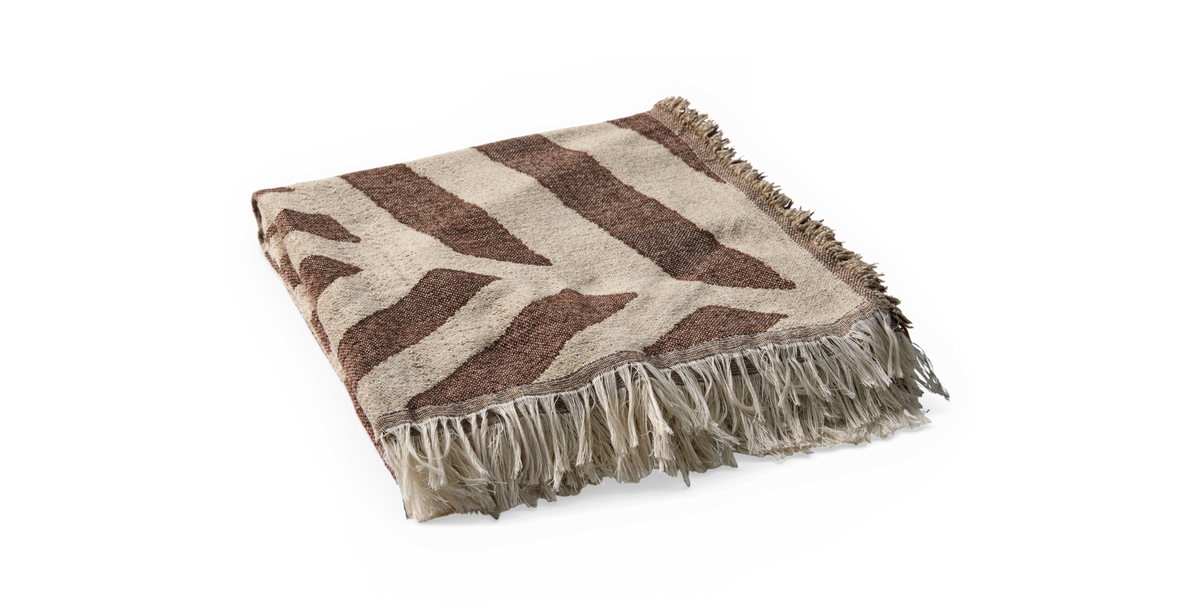 Sammenfoldet beige plaid med brune, organiske striber og lange frynser.