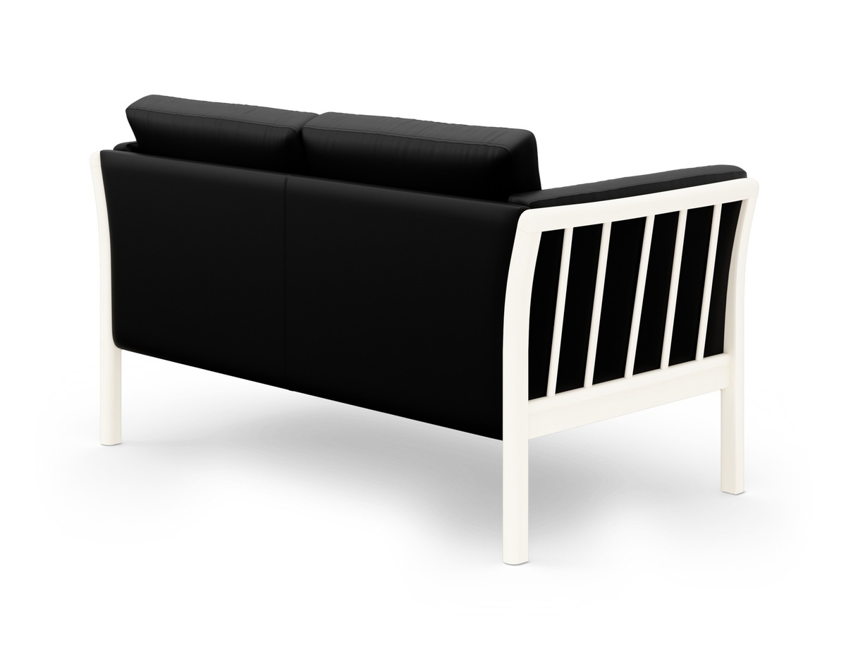 Sort 2-pers. sofa med hvid ramme set skråt bagfra på hvid baggrund.