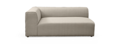 Beige modulsofa med ét armlæn, lav ryglæn og blødt afrundede kanter på sort baggrund.