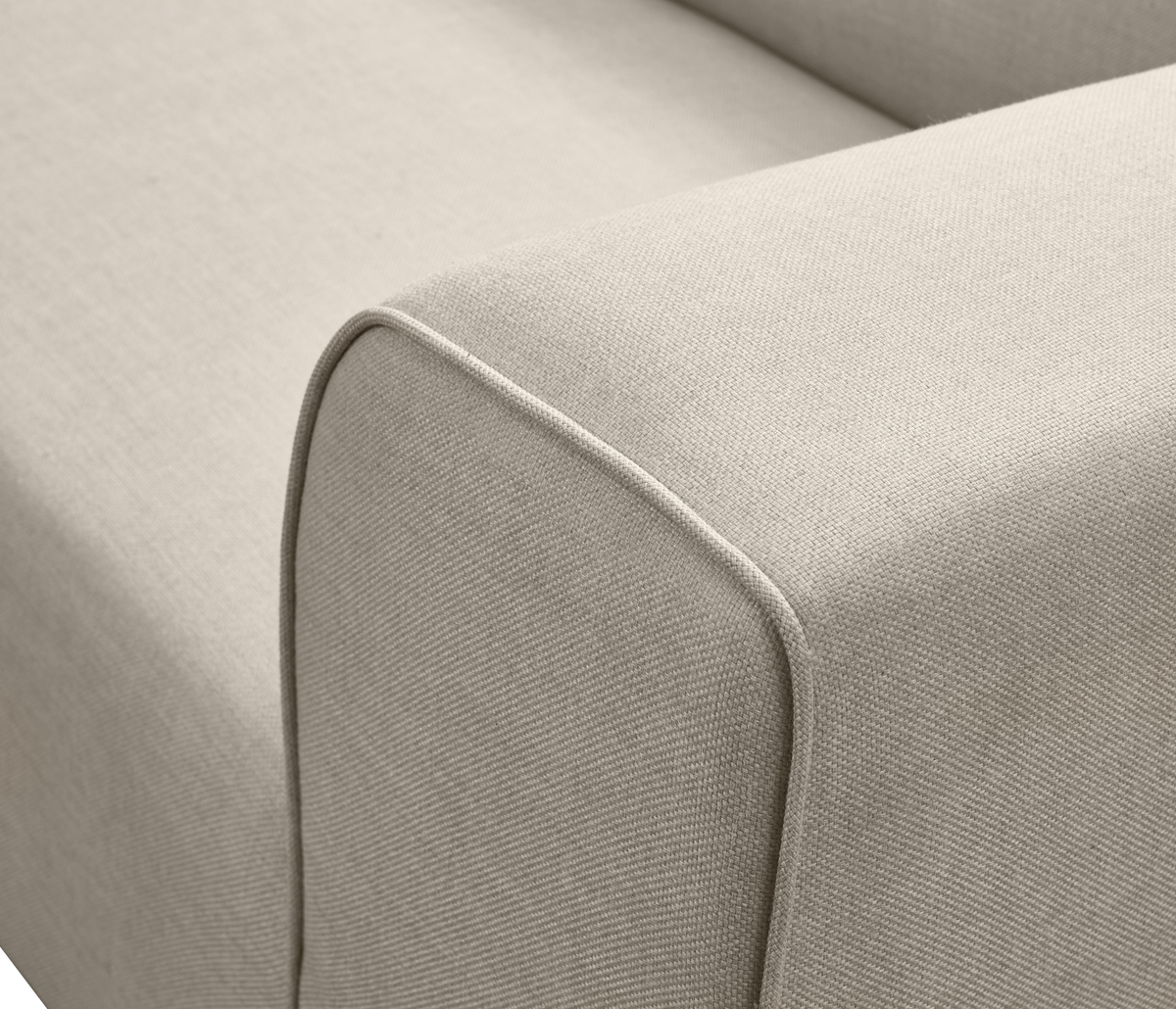Nærbillede af beige sofa-armlæn i tekstil med piping.
