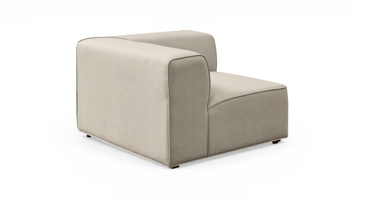 Beige modulsofa i stof – hjørnemodul med lav ryg, frilagt på hvid baggrund.