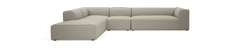 Modulær L‑formet beige stofsofa med chaiselong, fritlagt på sort baggrund.