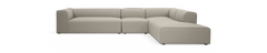 L-formet modulsofa i beige stof, frilagt på sort baggrund, set skråt forfra.