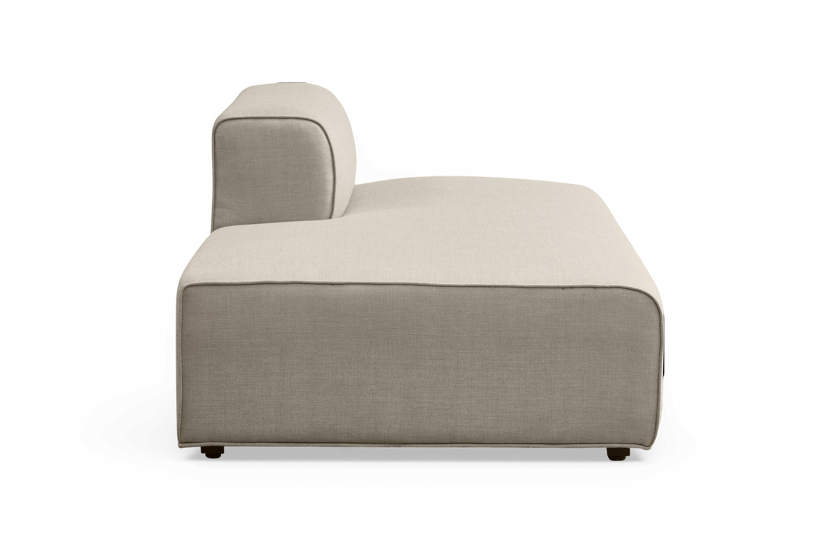 Beige modulsofa med venstre armlæn og chaiselong-del, set fra siden.