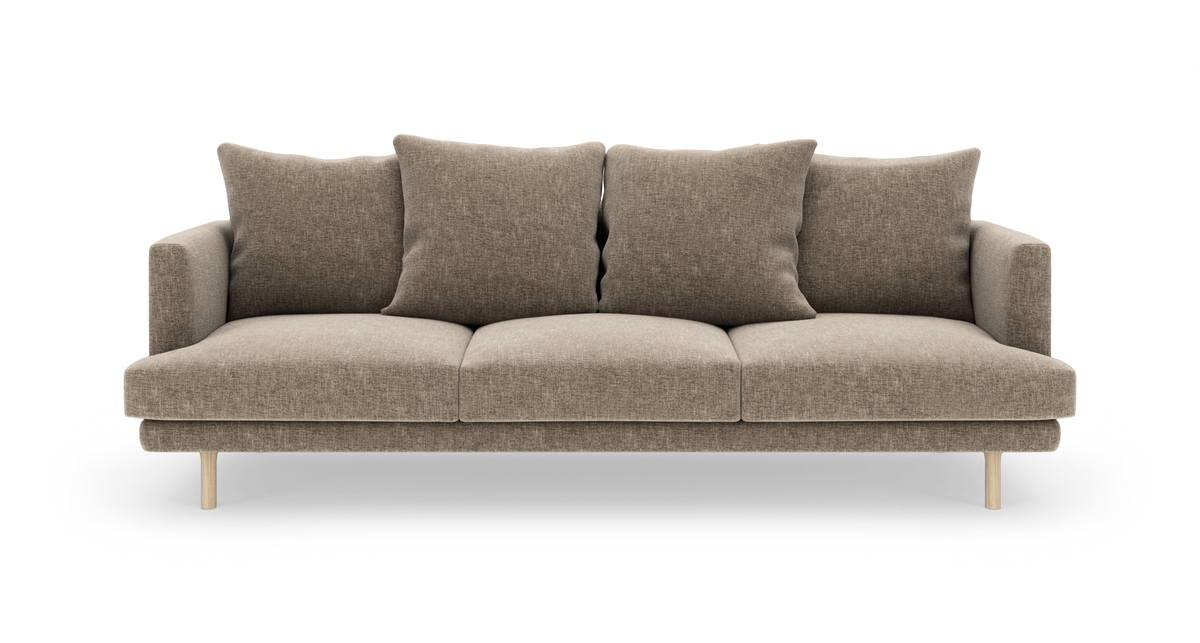 Beige 3-personers sofa med fire løse ryghynder og lyse træben, frilagt på hvid baggrund.