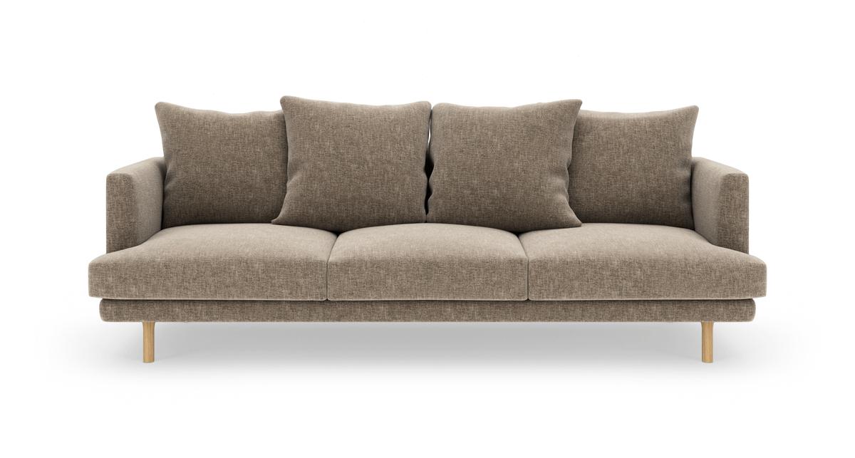 Beige 3‑personers sofa med fire ryghynder og træben, fotograferet lige for mod hvid baggrund.
