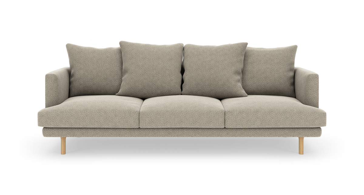 Beige 3-personers sofa med fire løse ryghynder og lyse træben, fritlagt på hvid baggrund.