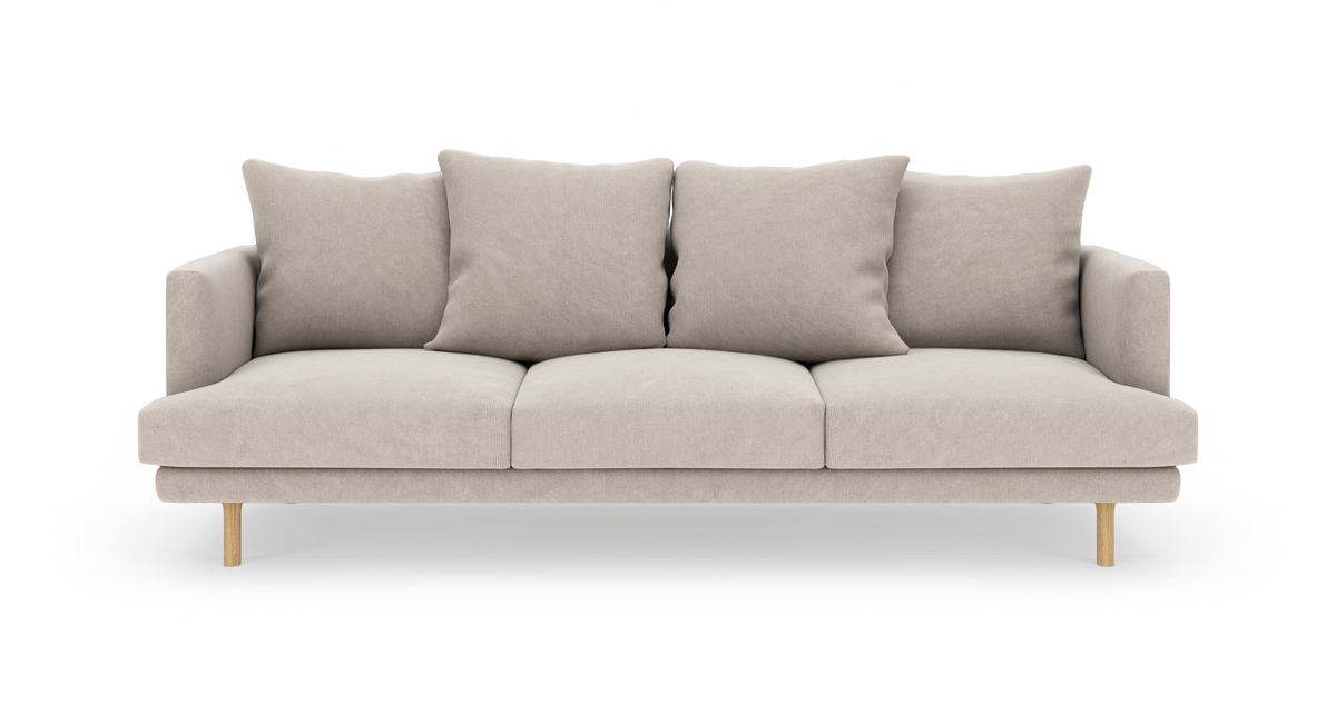 Beige 3-personers sofa med fire løse ryghynder og træben, frontvisning på hvid baggrund.