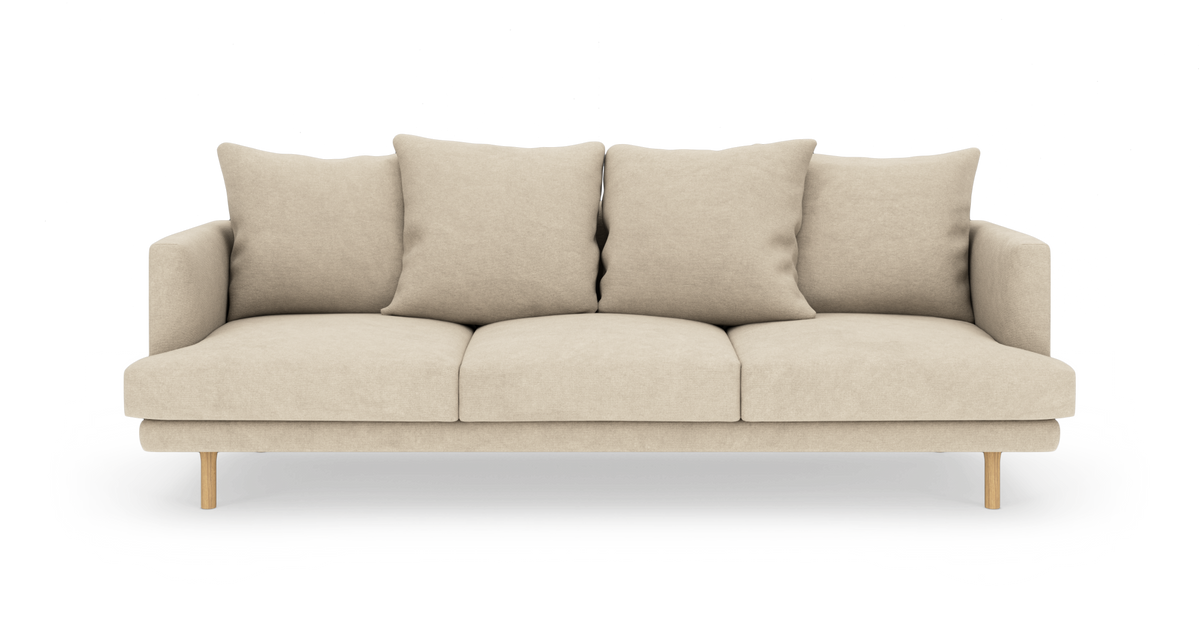 Beige 3-personers sofa med fire ryghynder og træben, fotograferet lige forfra mod hvid baggrund.