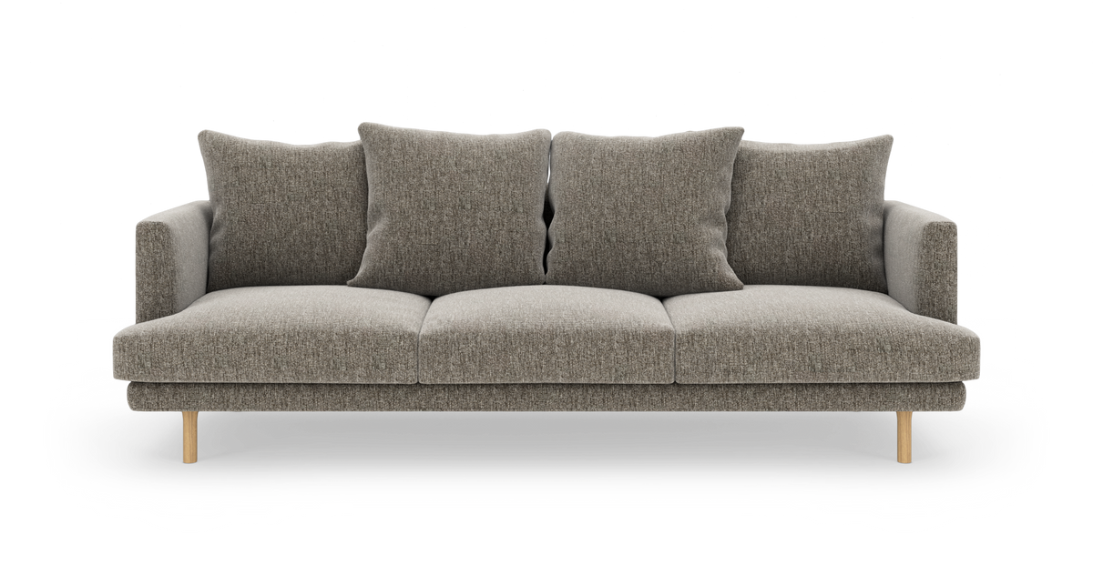Grå‑beige sofa med fire løse ryghynder og lyse træben, frilagt på hvid baggrund.