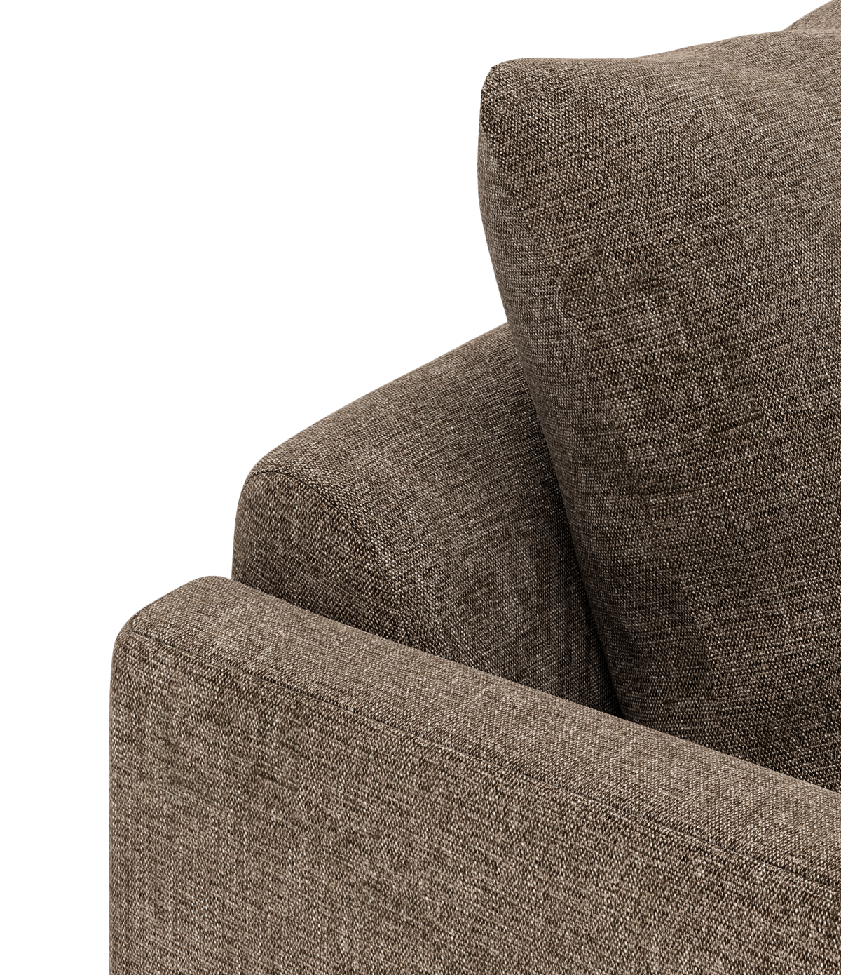Nærbillede af hjørnet på en brun stofsofa med pude.