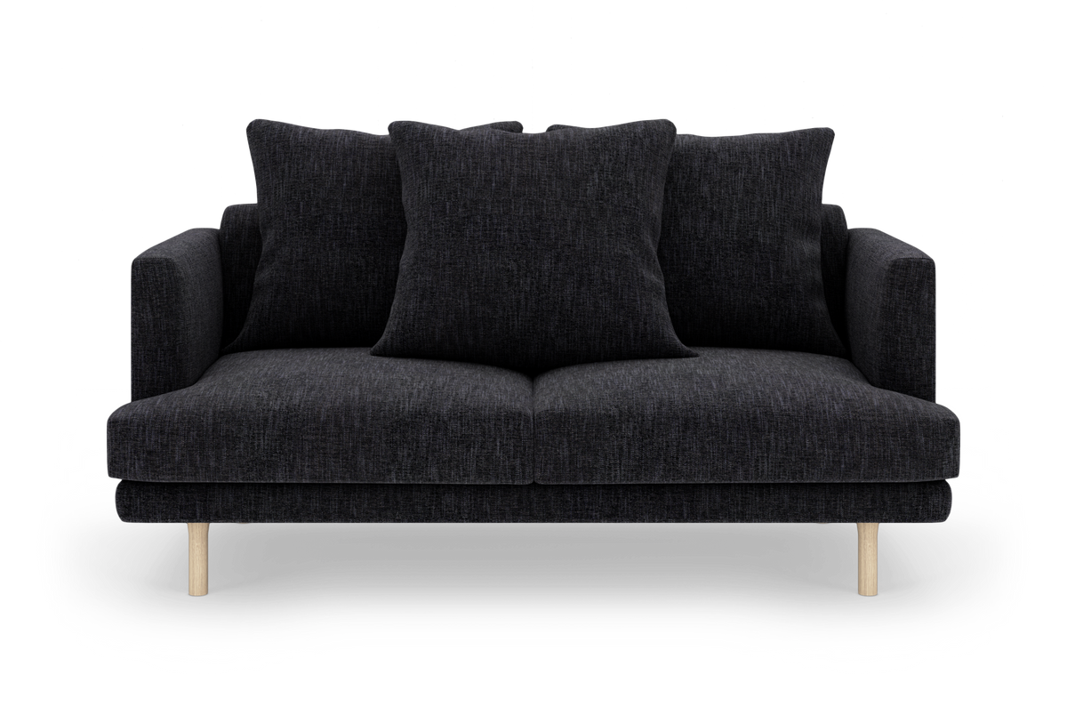 Sort 2-personers sofa med tre store mørke puder og lyse træben, frilagt på hvid baggrund.