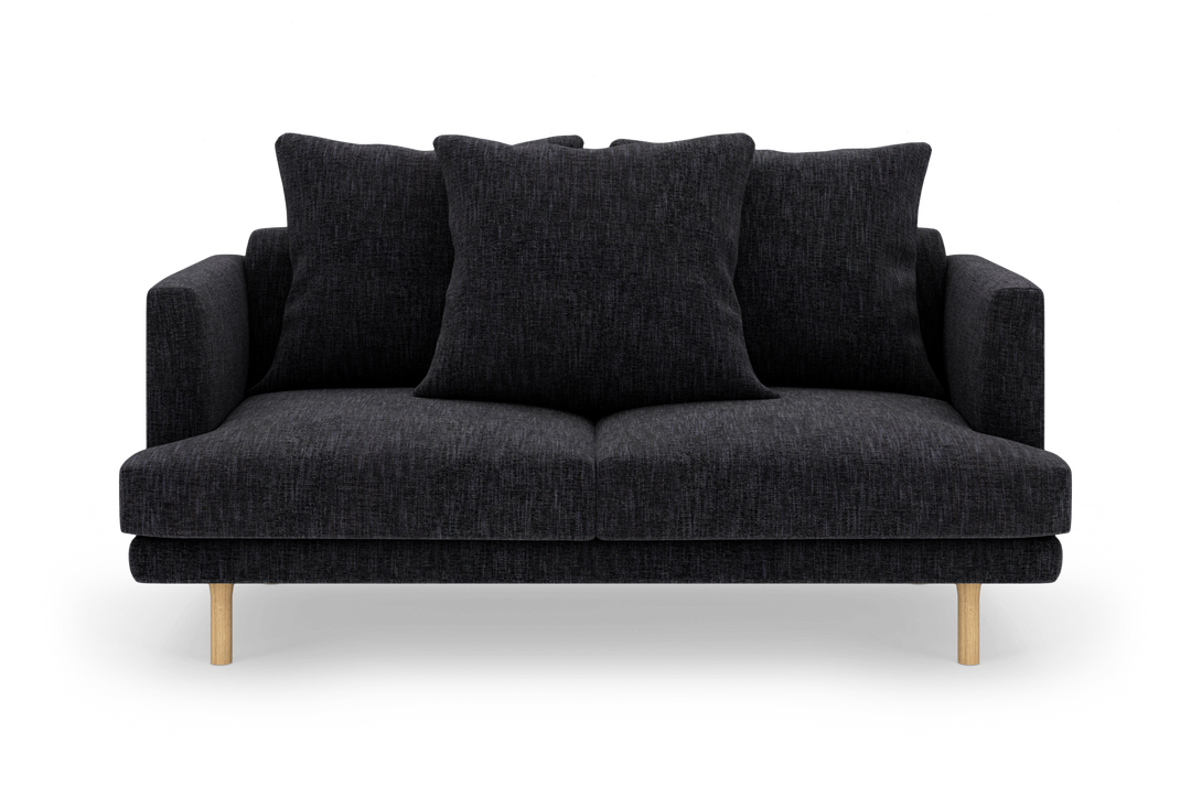 Mørkegrå sofa med tre store ryghynder og lyse træben, frilagt på hvid baggrund.