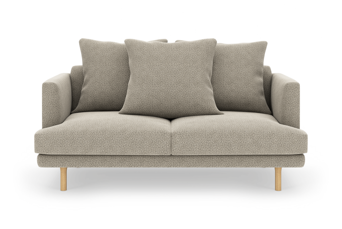 Beige 2-personers sofa i stof med tre store puder og lyse træben, fotograferet lige forfra.