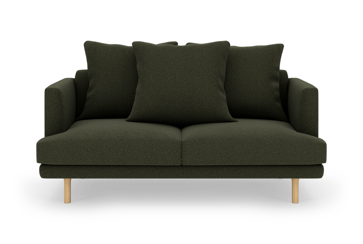 Mørkegrøn sofa med tre store puder og lyse træben, fritlagt på hvid baggrund.