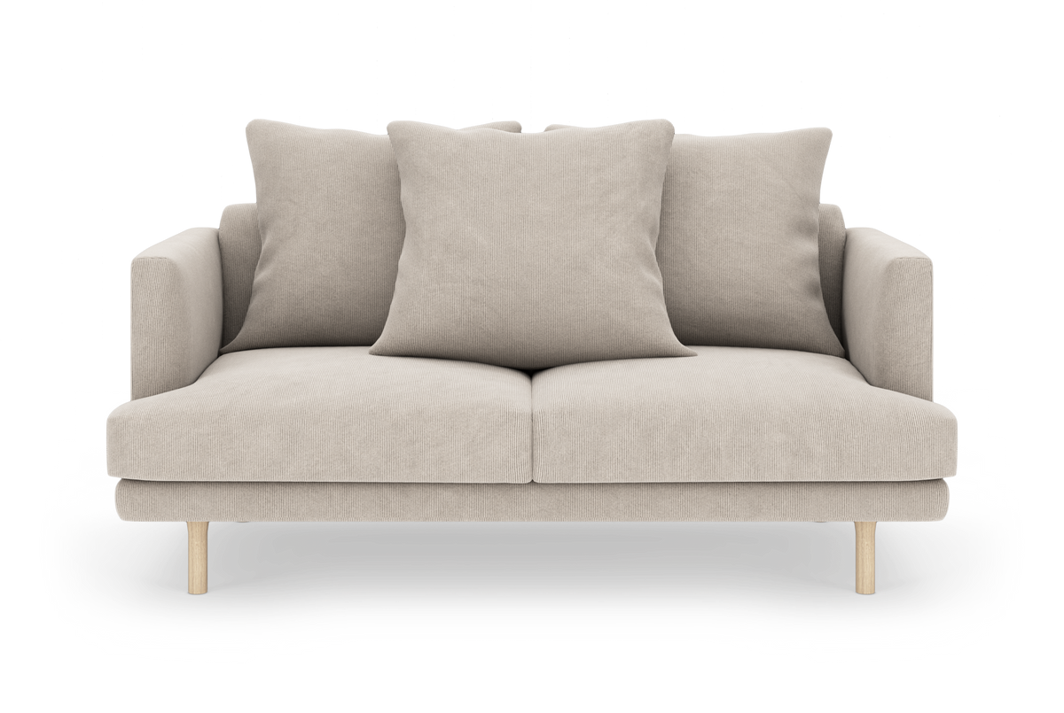 Beige 2-personers sofa med tre store puder, lige armlæn og lyse træben, fritlagt på hvid baggrund.