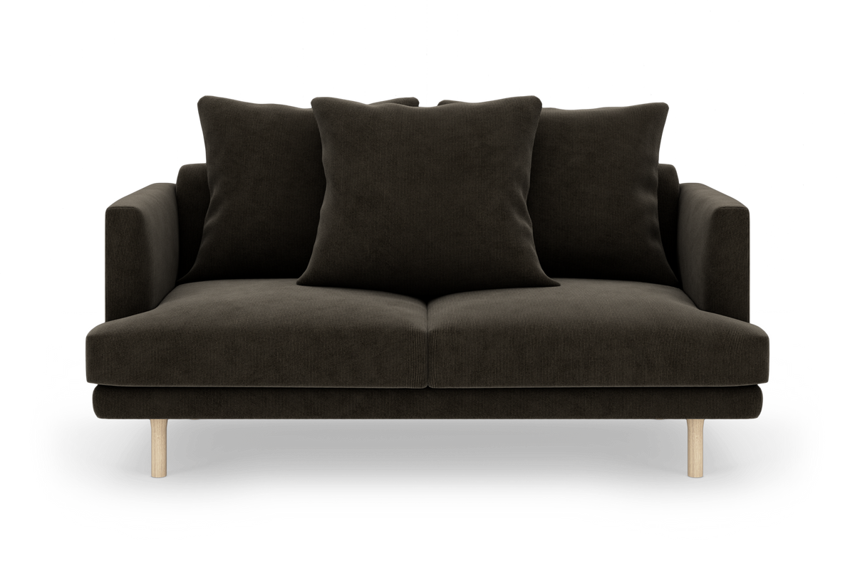 Mørk stofsofa med tre store puder og lyse træben, fotograferet lige forfra.